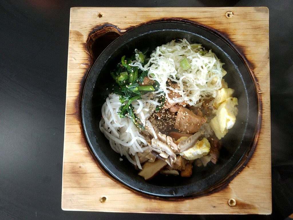 The sizzling-hot bibimbap bowls at K Fresh in Everett are served in wood boxes, which acquire charred edges from the hot stone. (Sara Bruestle / The Herald)
