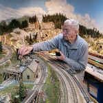 Tom Treanor, member of the Swamp Creek & Western Railroad Association, operating on a portion of the model railroad set in the Cascade mountains. (Photo by John Dineen)