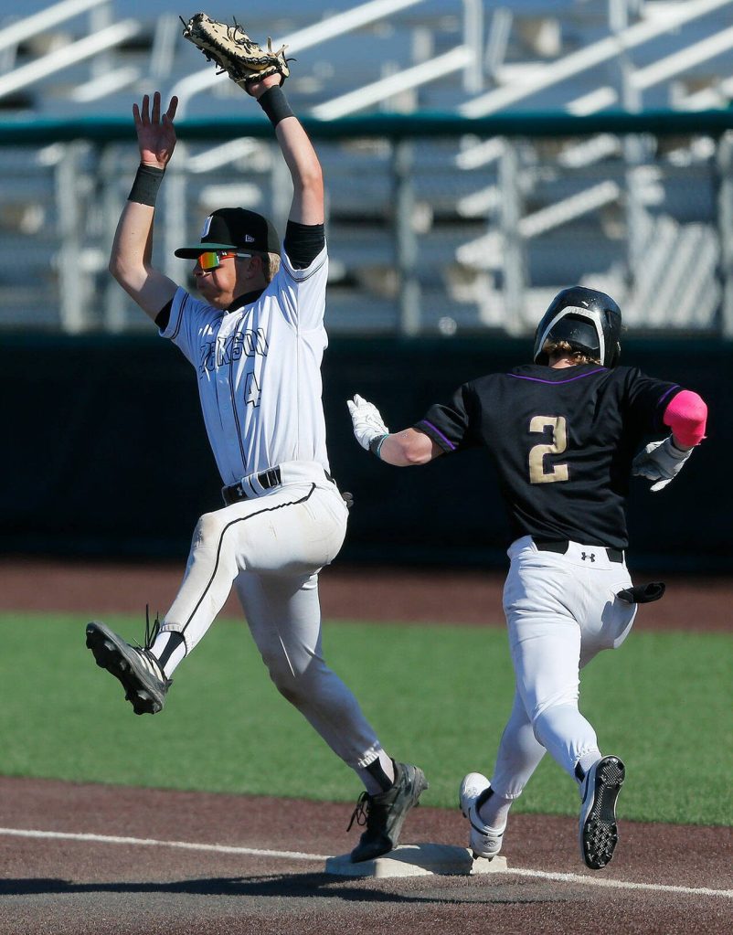 Jacksons Caden Davis keeps his foot on first while snagging a high throw against Lake Stevens during a Wesco 4A District 1/2 game on Thursday, May 11, 2023, at Funko Field in Everett, Washington. The runner, Lake Stevens Aspen Alexander, was called safe. (Ryan Berry / The Herald)