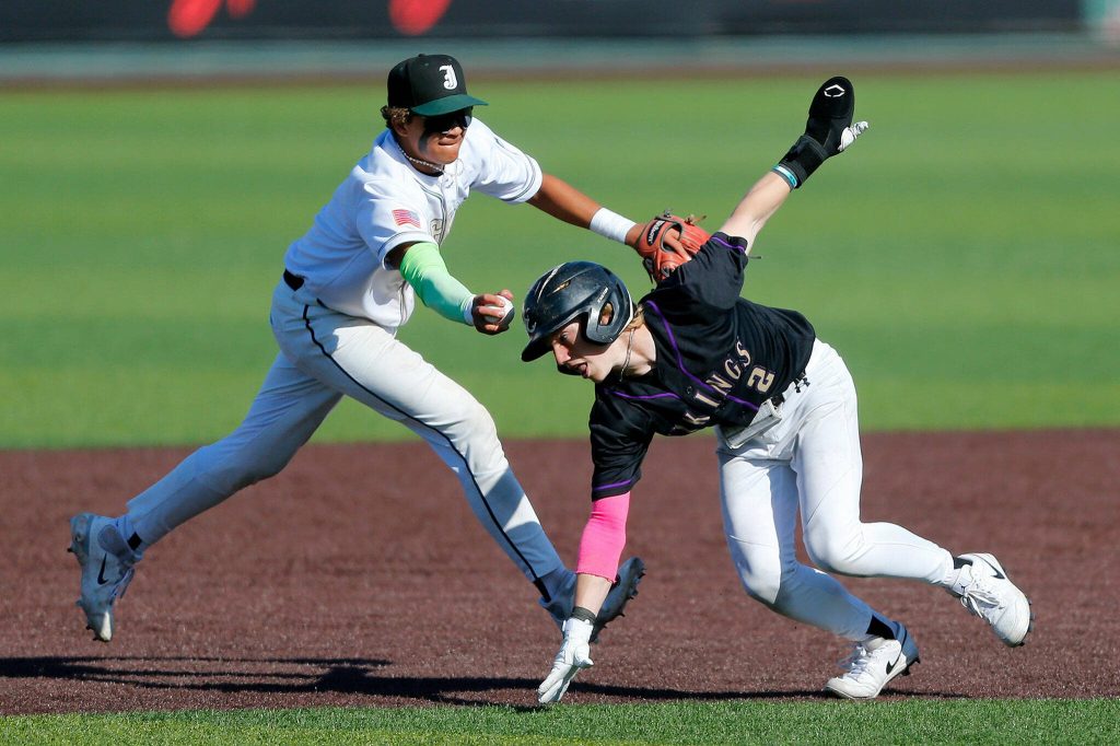 Lake Stevens Aspen Alexander tries to evade Jackson shortstop Micah Coleman after getting caught in a pickle on a pickoff at first during a Wesco 4A District 1/2 game on Thursday, May 11, 2023, at Funko Field in Everett, Washington. (Ryan Berry / The Herald)