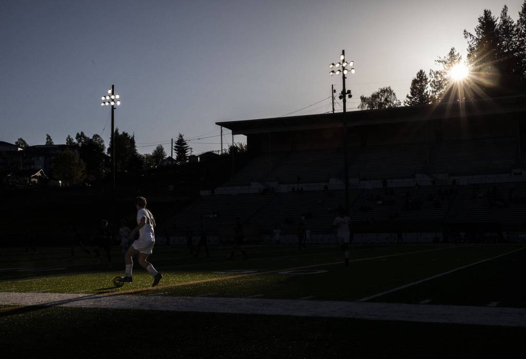 Bothells Lucas Renggli dribbles through a patch of sunlight on the field during the game against Jackson on Thursday, May 11, 2023 in Everett, Washington. (Olivia Vanni / The Herald)