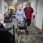 CNA Nina Prigodich, right, goes through restorative exercises with long term care patient Betty Long, 86, at View Ridge Care Center on Friday, Feb. 10, 2023 in Everett, Washington. (Olivia Vanni / The Herald)