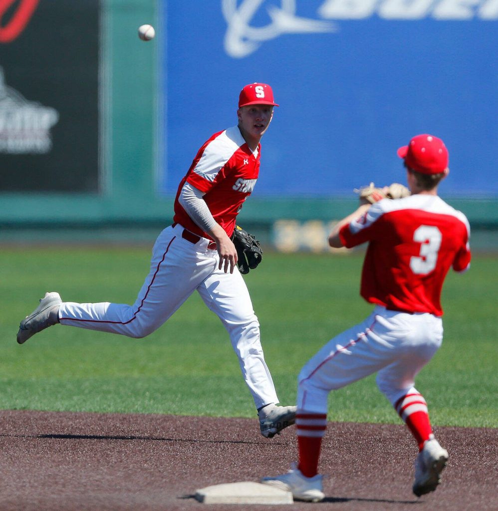 Stanwood’s Caden Caldero flips a grounder to Tryston Stephenson for a force out against Monroe in a winner-to-state consolation game on Saturday, May 13, 2023, at Funko Field in Everett, Washington. (Ryan Berry / The Herald)
