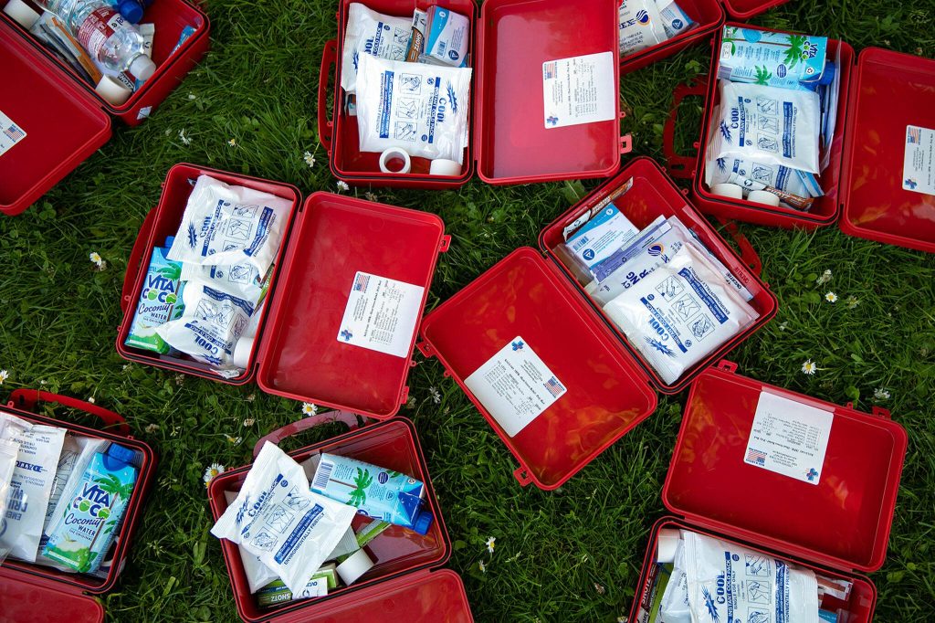 Heat stress kits are put together before being given out at a community gathering protesting Everetts expanded no sit, no lie ordinance Sunday, May 14, 2023, at Clark Park in Everett, Washington. (Ryan Berry / The Herald)
