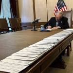 Washington Gov. Jay Inslee signs bills at the Washington State Capitol, Tuesday, May 9, 2023, in Olympia, Wash. One of those bills was Senate Bill 5599, which was designed to protect young people seeking reproductive health services or gender-affirming care. (AP Photo/Ed Komenda)