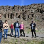 Tribal elder and storyteller Randy Lewis stands in front of the Singing Rocks of Moses Coulee, explaining how they absorbed the voices of his people and how those voices can still be heard – if the conditions are right. (Dominick Bonny / Crosscut)