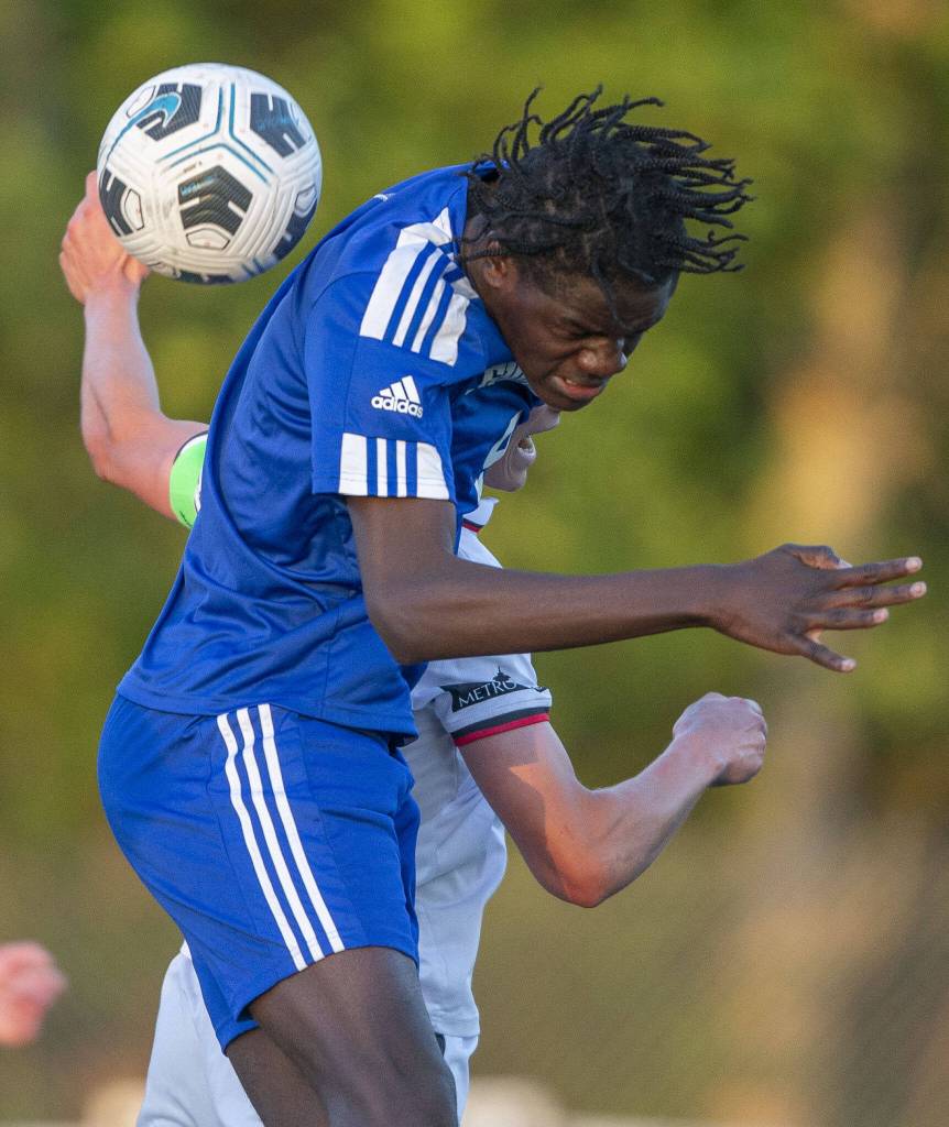 Shorewoods Anthony Henry leaps in the air for a head ball during the game against Ballard on Thursday, May 18, 2023 in Shoreline, Washington. (Olivia Vanni / The Herald)