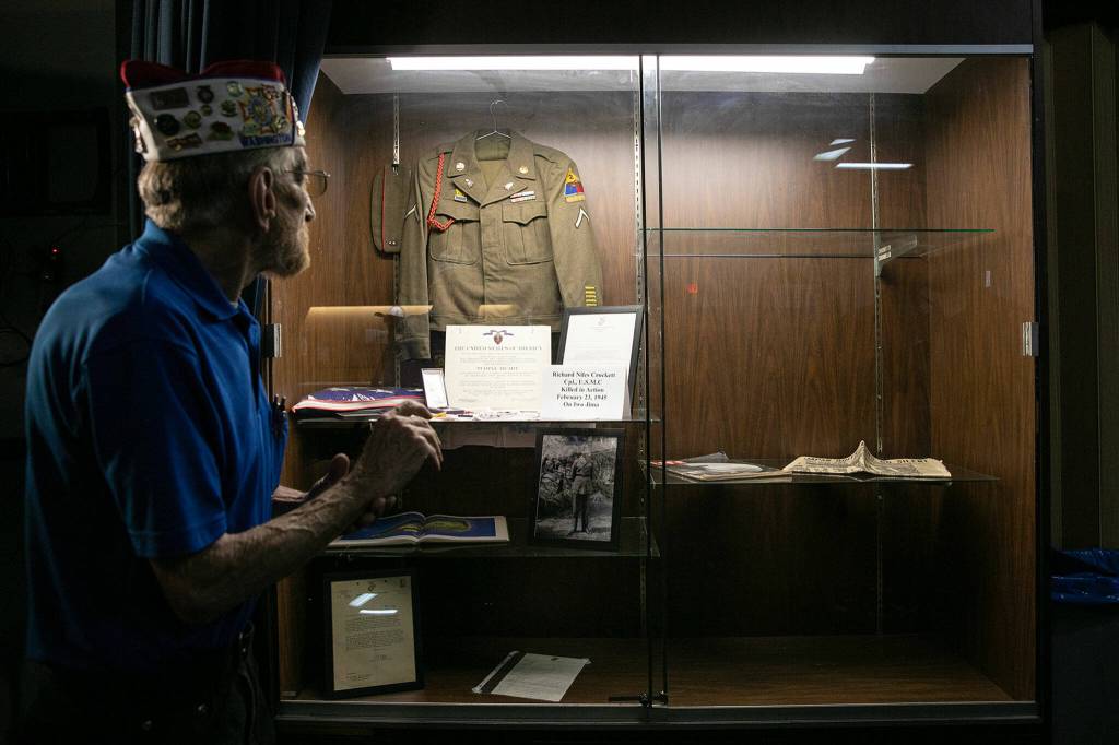 Donald Wischmann, quartermaster of VFW Post 2100 in Everett, stands in front of a display case with war memorabilia on Friday, May 26, 2023, in Everett, Washington. With the Help of Paul Davis Restoration, Wischmann hopes to fill the display case with restored artifacts that have been in the VFWs basement.(Ryan Berry / The Herald)