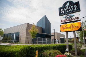 A sign announcing a soon to open Woods Coffee in Everett Marina Village at the Port of Everett on Wednesday, May 24, 2023. (Olivia Vanni / The Herald)