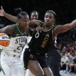 Seattle Storm guard Jewell Loyd (24) drives into Las Vegas Aces guard Jackie Young (0) during the second half in Game 2 of a WNBA basketball semifinal playoff series Wednesday, Aug. 31, 2022, in Las Vegas. (AP Photo/John Locher)