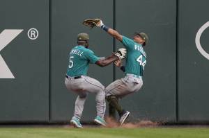 Mariners center fielder Julio Rodriguez (44) avoids teammate Taylor Trammell as he catches a fly ball by the Braves Ronald Acuna Jr. in the third inning of a game Saturday in Atlanta. (AP Photo/John Bazemore)