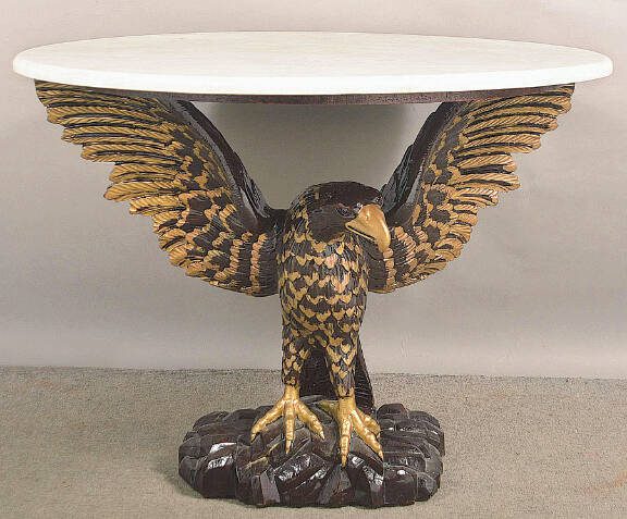 Eagles are a powerful symbol in American designs from the Great Seal to everyday decorative arts. A carved eagle holds up this tables faux marble top.