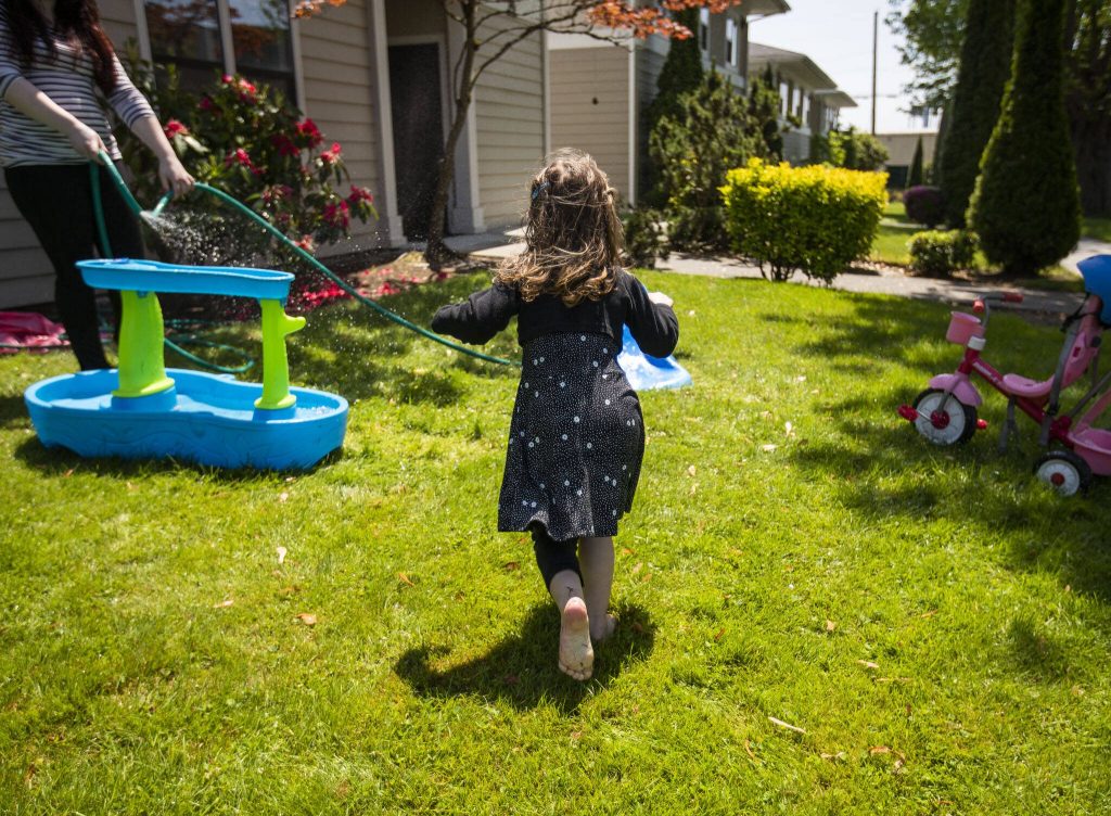 A young girl plays outside of Evergreen Recovery Center with her mother on Thursday, May 25, 2023 in Everett, Washington. (Olivia Vanni / The Herald)