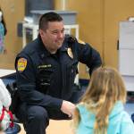 Lieutenant Greg Sutherland of the Everett Police Department hangs out with some students during a free pancake breakfast at Lowell Elementary School on Friday, May 26, 2023, in Everett, Washington. (Ryan Berry / The Herald)