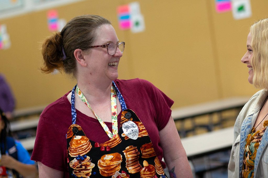 Teacher Stacey Wartenbee circles the cafeteria and chats with folks during a free pancake breakfast she organized at Lowell Elementary School on Friday, May 26, 2023, in Everett, Washington. (Ryan Berry / The Herald)