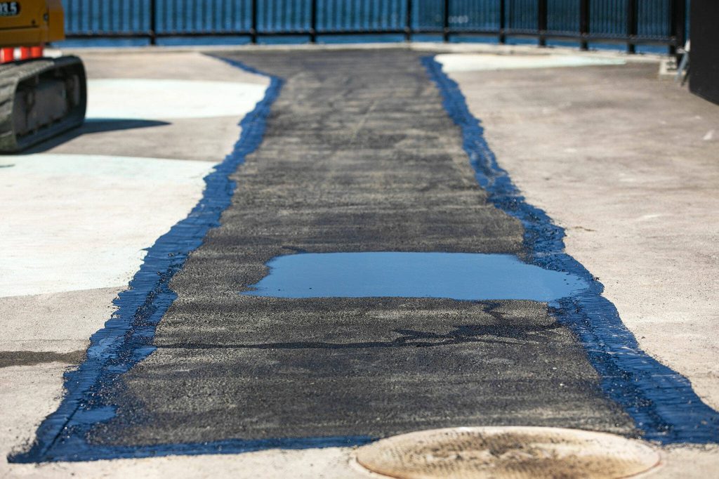A fresh patch of asphalt covers part of the parklet next to Ivars on Thursday, May 25, 2023, in Mukilteo, Washington. (Ryan Berry / The Herald)