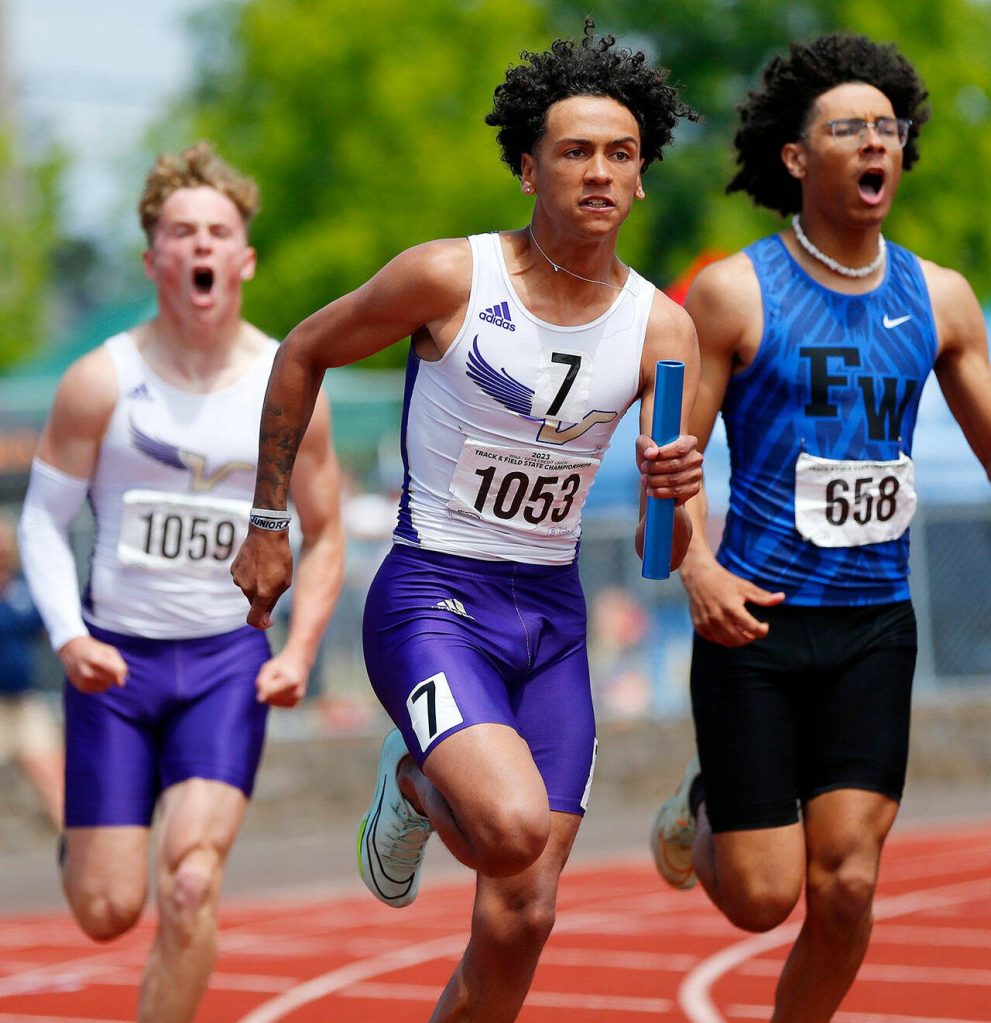 Lake Stevens senior Grant Buckmiller takes off with the baton after a handoff from teammate Jesse Lewis in the boys 4A 4x100 relay during the WIAA State Track and Field Championships on Saturday, May 27, 2023, at Mount Tahoma High School in Tacoma, Washington. (Ryan Berry / The Herald)