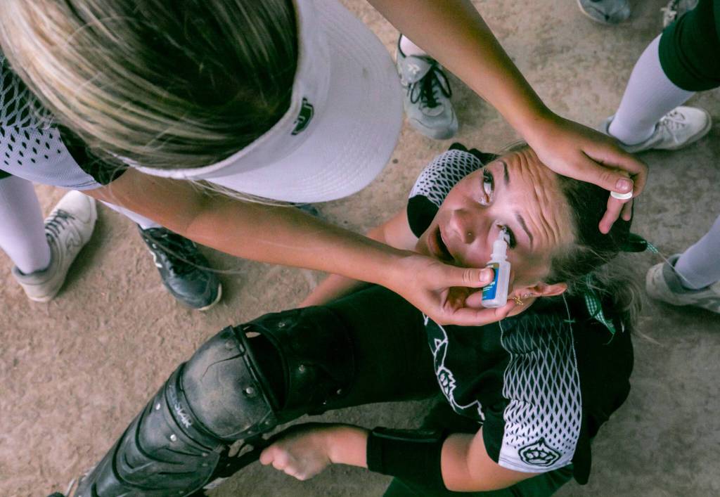 Jackson catcher Leneyah Mitchell (10) gets eye drop treatments after a storm kicks dust into her eyes during the WIAA Class 4A state softball title game on Saturday, May 27, 2023, in Richland. (TJ Mullinax / For The Herald)