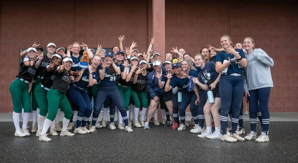 Both WIAA Class 4A softball championship teams, Jackson and Glacier Peak, pose together before hearing the outcome of their storm-delayed game on Saturday, May 27, 2023, in Richland. (TJ Mullinax / For The Herald)