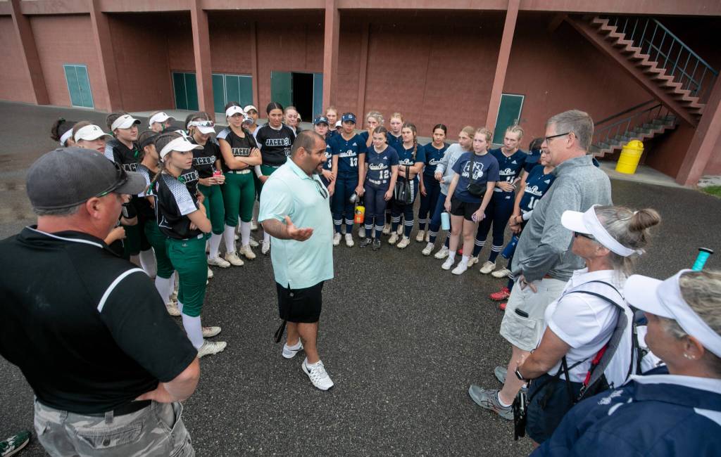 Adrian Ochoa, Richland High School athletic director (center) talks to Jackson and Glacier Peak players and coaches about the storm delay and the decision by both schools to call the game final in the 6th inning, resulting in Jackson winning the 2023 WIAA Class 4A softball championship on Saturday, May 27, 2023, in Richland. (TJ Mullinax / For The Herald)