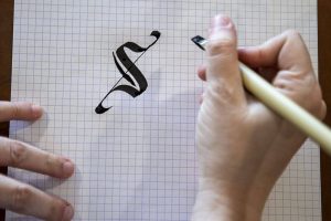 Chelsea Bridges Wagner, 35, practices calligraphy at her home in Snohomish, Washington on Wednesday, March 29, 2023.  (Annie Barker / The Herald)