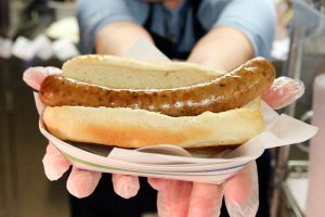 Tammy Ohrmund displays a bacon sausage hot dog that is sold on the ferries. (Kevin Clark / The Herald)