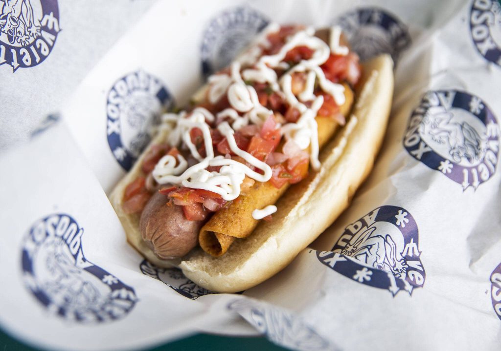The Tri-City Dust Devils Taquito Dog is made with a taquito, sour cream and pico de gallo. (Olivia Vanni / The Herald)