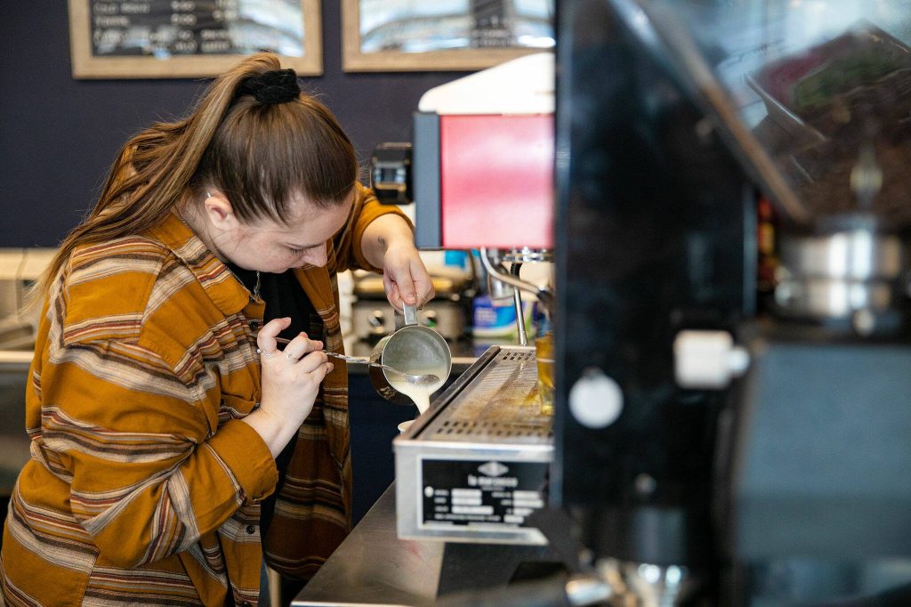 Augusta Cahill pours a latte for a customer at Crabby Coffee on Wednesday, April 5, 2023, in Coupeville, Washington. (Ryan Berry / The Herald)
