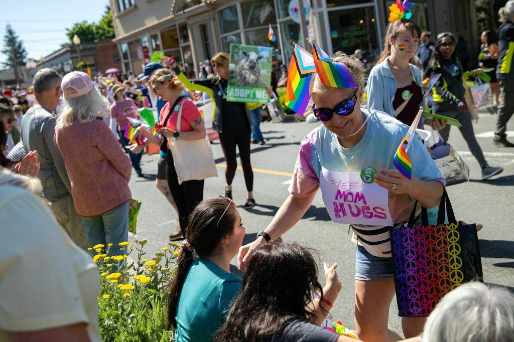 A woman gives out free mom hugs while parading in Snohomishs inaugural Pride celebration on Saturday, June 3, 2023, in downtown Snohomish, Washington. (Ryan Berry / The Herald)