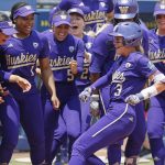 Washington players celebrate a home run by Rylee Holtorf (3) at home plate during the second inning of a Womens College World Series game against Utah on Friday in Oklahoma City. (AP Photo/Nate Billings)