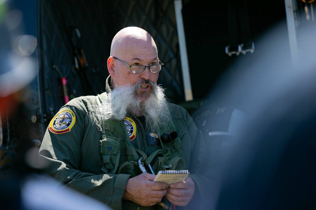Paul Moutray, crew chief for Snohomish County Volunteer Search and Rescue, speaks to a group of emergency responders from South County and Seattle fire departments during an interagency disaster response training exercise at Arlington Municipal Airport on Tuesday, June 6, 2023, in Arlington, Washington. (Ryan Berry / The Herald)