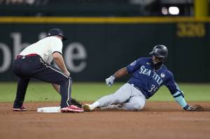 Rangers shortstop Corey Seager (left) reaches down to tag out the Mariners Teoscar Hernande, who was trying to stretch a single into a double during the third inning of a game Friday in Arlington, Texas. (AP Photo/Tony Gutierrez)