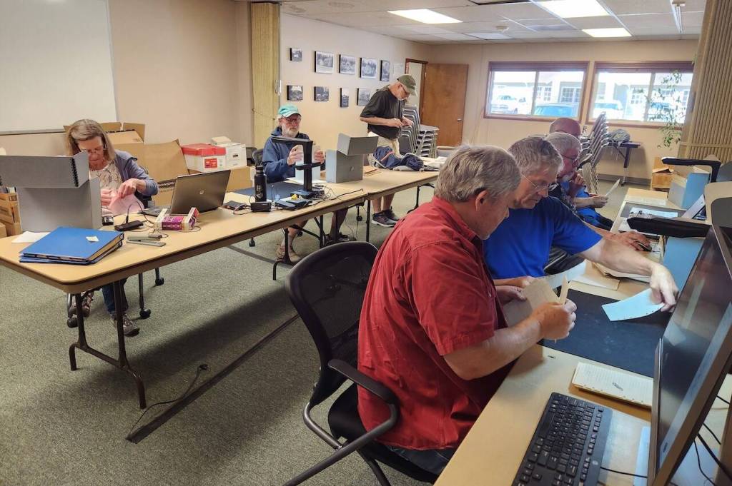 Volunteers combed through historic documents at the Darrington Ranger Station on May 20, 2023, in Darrington, Washington. (Adam Sowards / For The Herald)