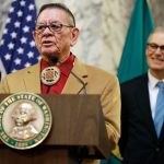 Sen. John McCoy, D-Tulalip, left, a member of the Tulalip Tribes of Washington, speaks Wednesday, Feb. 22, 2017, as Washington Gov. Jay Inslee, right, looks on at the Capitol in Olympia, Wash. After the speech, Inslee signed a bill sponsored by McCoy that seeks to improve oral health on Indian reservations in Washington state. The measure is the first bill the governor has signed this legislative session and it allows tribes to use federal funding for dental therapists. (AP Photo/Ted S. Warren)