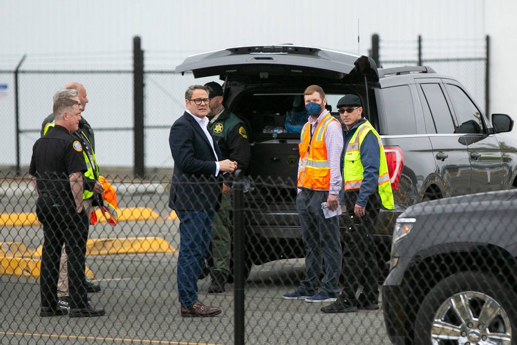 Brett Smith, CEO of Propeller Airports, meets with law enforcement and others outside Paine Fields terminal after the discovery of a suspicious package at the airport on Tuesday, June 13, 2023, in Everett, Washington. (Ryan Berry / The Herald)