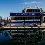Islanders disembark the Hat Island Ferry, which is called the Hat Express, in 2018. At the top of the ramp stands Ray Brown, the captain. Below him on the dock are crew members Ryan Taisey, first mate (left) and Michael Jablinske. (Dan Bates / The Herald)