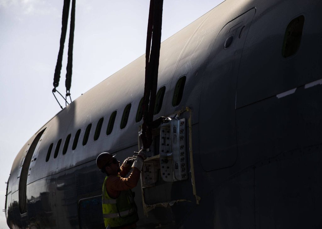 Omega Morgan employees unhook the fuselage after it is placed on Thursday, June 15, 2023 in Everett, Washington. (Olivia Vanni / The Herald)