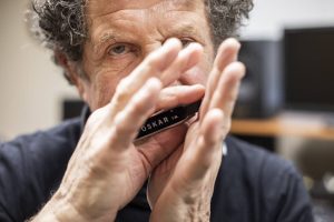 Lee Oskar plays on one of his custom harmonicas in his recording studio in his home on Wednesday, March 2, 2022 in Everett, Washington. (Olivia Vanni / The Herald)