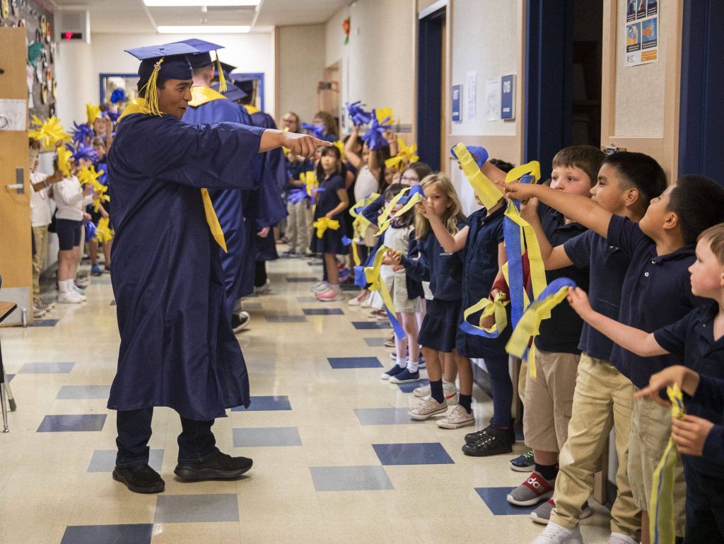 A graduate points to a Whittier Elementary School student they recognize on Friday, June 16, 2023 in Everett, Washington. (Olivia Vanni / The Herald)