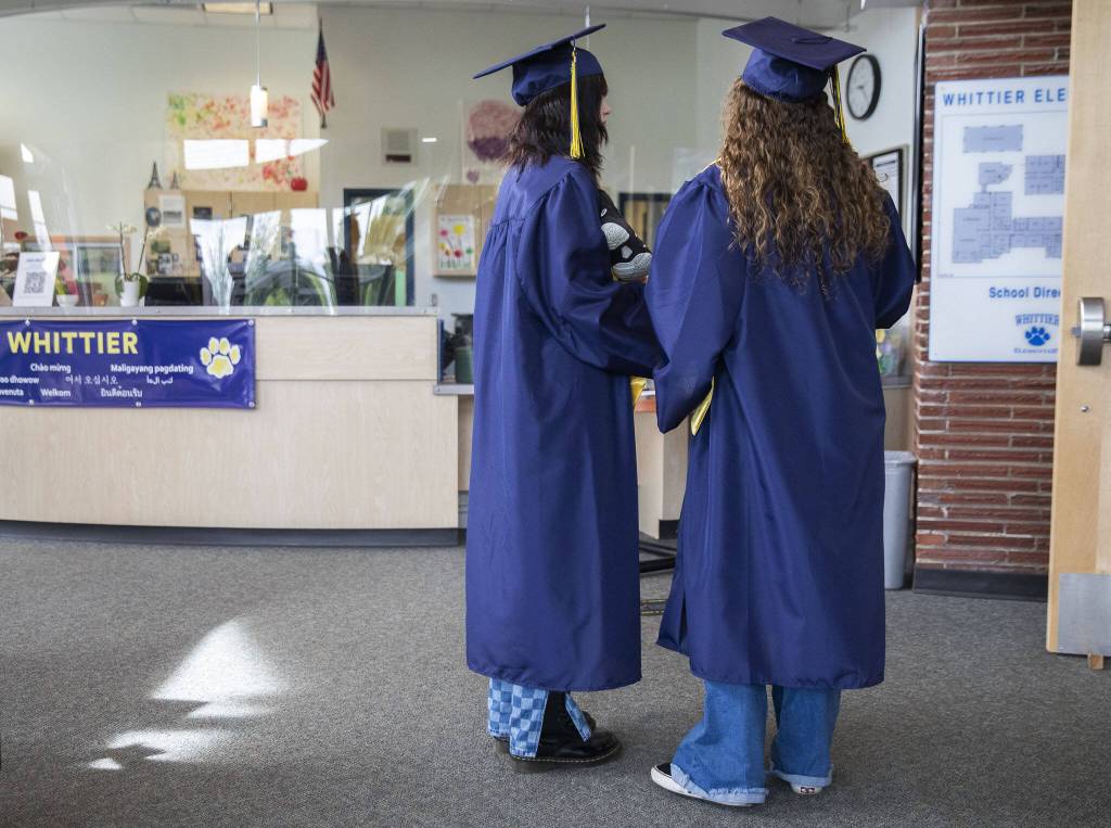 Everett High School graduates gather in the lobby of Whittier Elementary School on Friday, June 16, 2023 in Everett, Washington. (Olivia Vanni / The Herald)