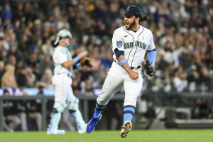 Seattle Mariners third baseman Eugenio Suarez, right, reacts after getting an out against Chicago White Sox's Zach Remillard after recovering a bunt during the ninth inning of a baseball game, Sunday, June 18, 2023, in Seattle. (AP Photo/Caean Couto)