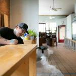 Adair Gearhart sands down a shelf while piecing together the future home of Catalyst Café on Tuesday, June 20, 2023, in downtown Everett, Washington. Gearhart has already moved out of Catalysts 23rd Street storefront and hopes the new location will evolve into a gathering place with more food and drink, longer hours, and even more resources and connections for the queer community. (Ryan Berry / The Herald)