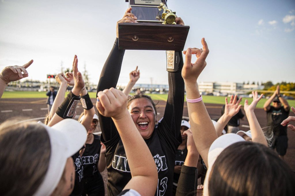 Jackson’s Yanina Sherwood lifts the district trophy in the air after beating Bothell to become the 3A district champions on Friday, May 19, 2023 in Everett, Washington. (Olivia Vanni / The Herald)