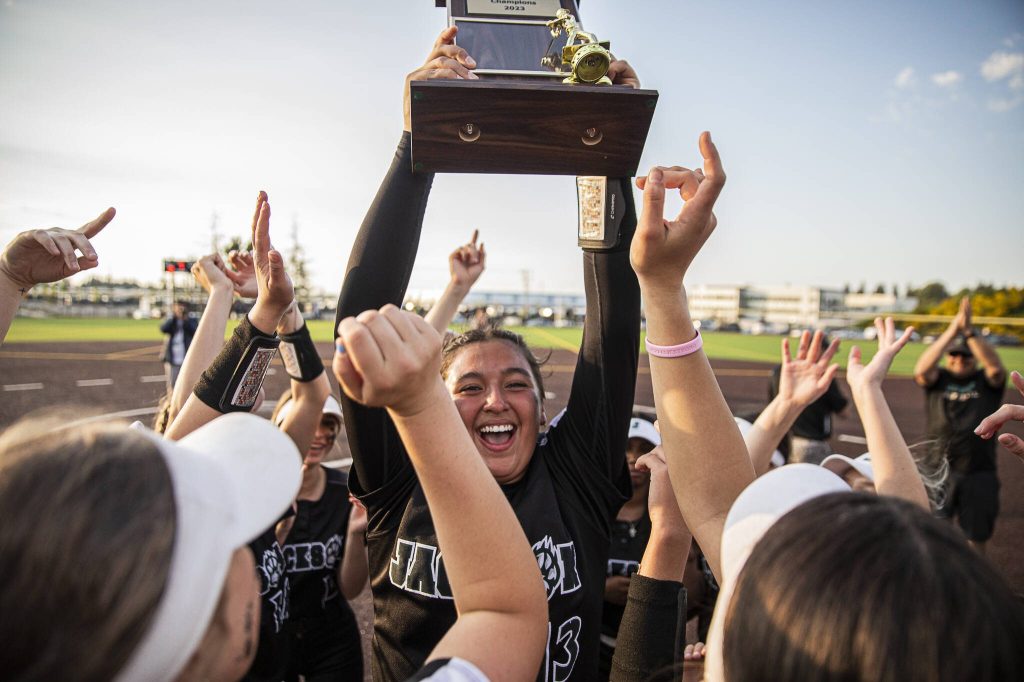 Jackson’s Yanina Sherwood lifts the district trophy in the air after beating Bothell to become the 3A district champions on Friday, May 19, 2023 in Everett, Washington. (Olivia Vanni / The Herald)