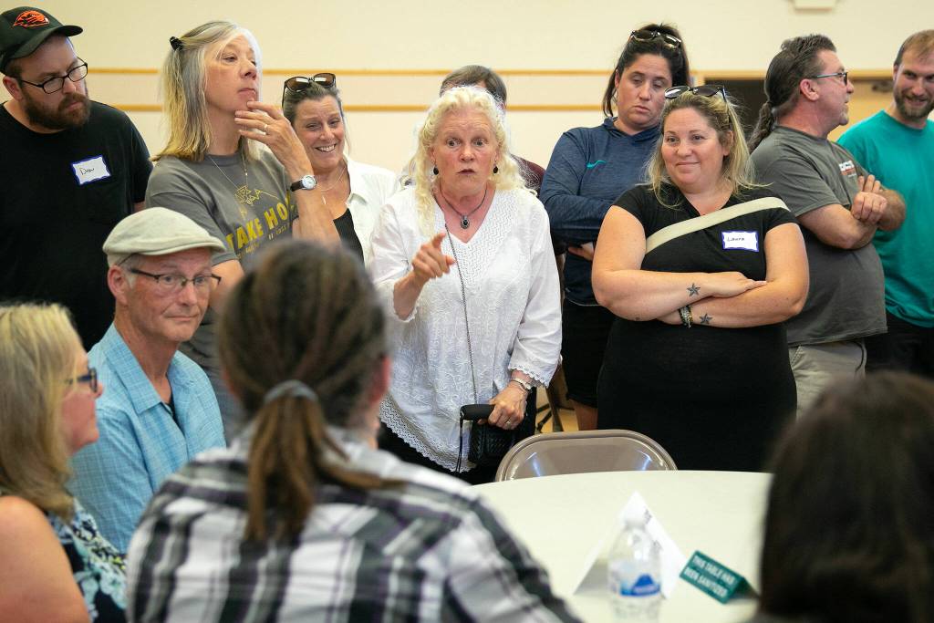 Community members voice concern about a proposed homeless day shelter to Everett Homeless Response Coordinator Ben Breeden, foreground, during a public meeting at Our Lady of Hopes parish hall Thursday, June 29, 2023, in Everett, Washington. (Ryan Berry / The Herald)