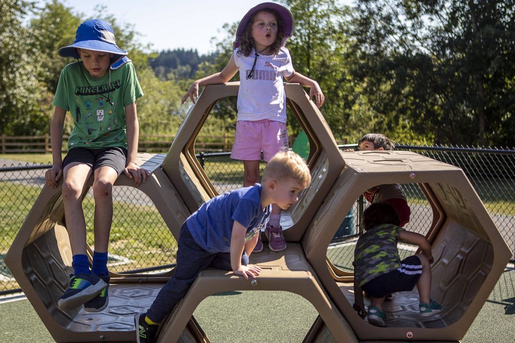 Children play on a honeycomb shaped structure at the Hazel Miller Universally Accessible Playground at Ballinger Park in Mountlake Terrace, Washington on Wednesday, June 28, 2023. (Annie Barker / The Herald)