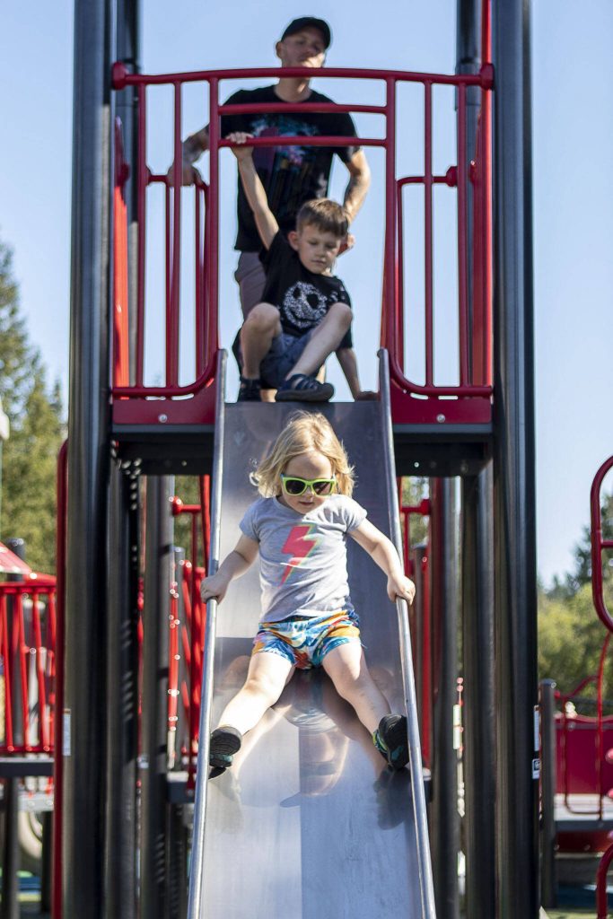 Zoey Odell, 3, plays on a slide at the Hazel Miller Universally Accessible Playground at Ballinger Park in Mountlake Terrace, Washington on Wednesday, June 28, 2023. (Annie Barker / The Herald)