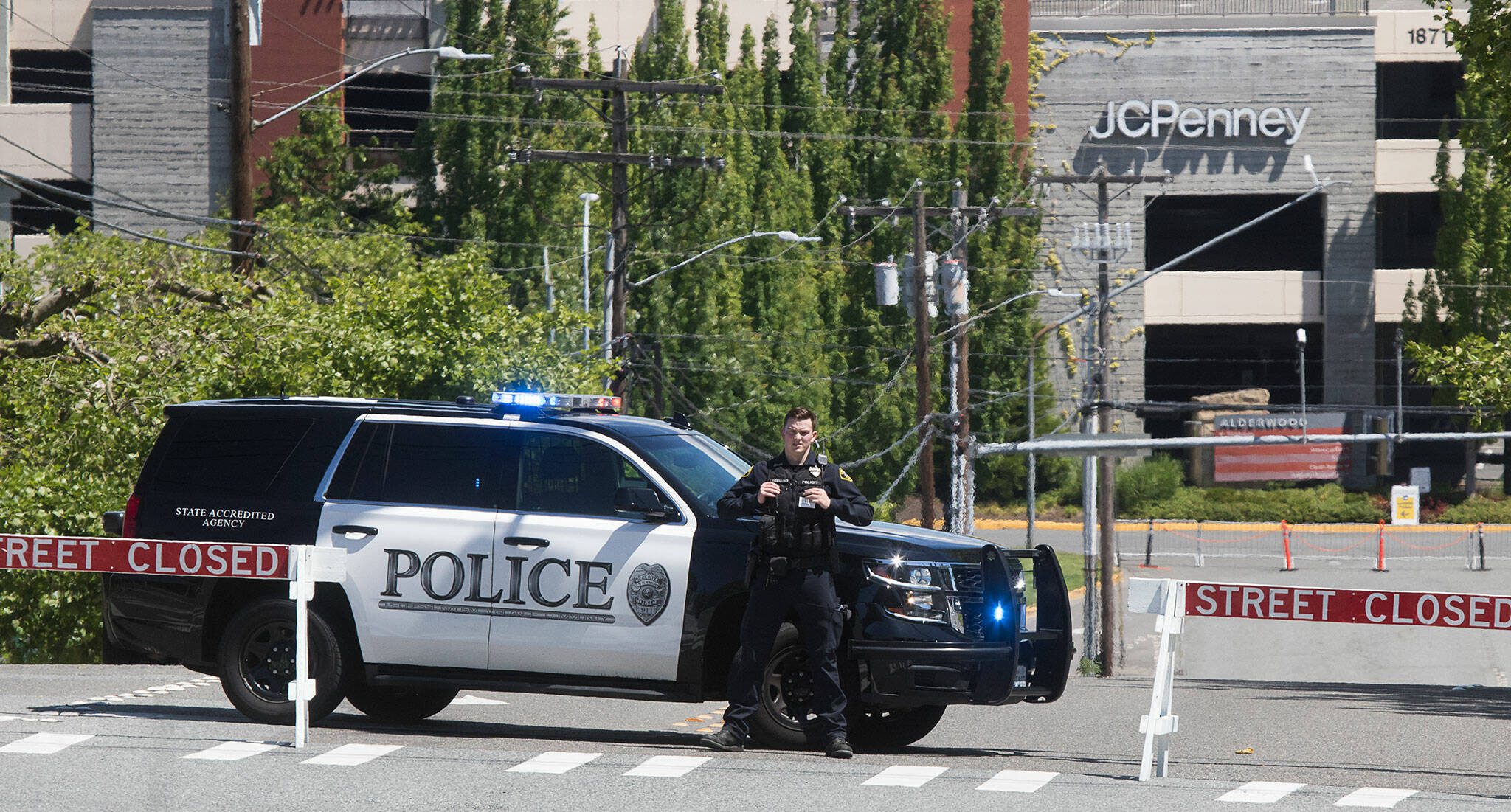 A Lynnwood police officer stands next to a police car. The Police Department purchased new GPS-based pursuit technology which mount on the front of patrol cars. (Andy Bronson / The Herald file)