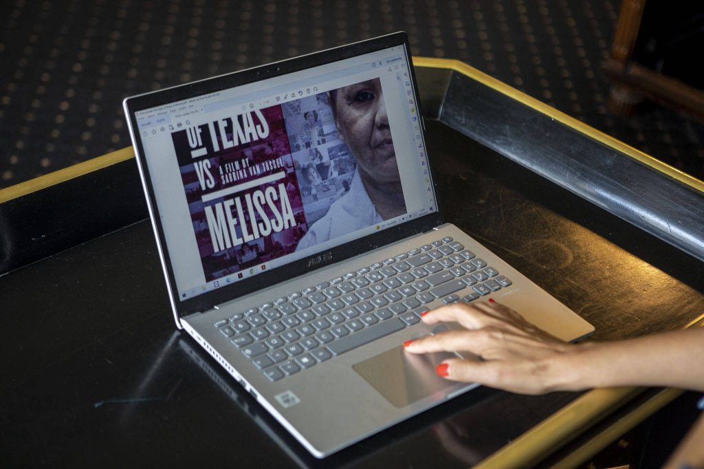 Sabrina Van Tassel pulls up press releases and news articles from past films on Wednesday, June 14, 2023, at Hotel Sorrento in Seattle, Washington. (Annie Barker / The Herald)