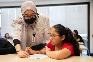 Ashley Cabrera, 9, right, looks up while thinking through a math problem with the help of tutor Aleesya Jasmi on Thursday, June 8, 2023 in Everett, Washington. (Olivia Vanni / The Herald)